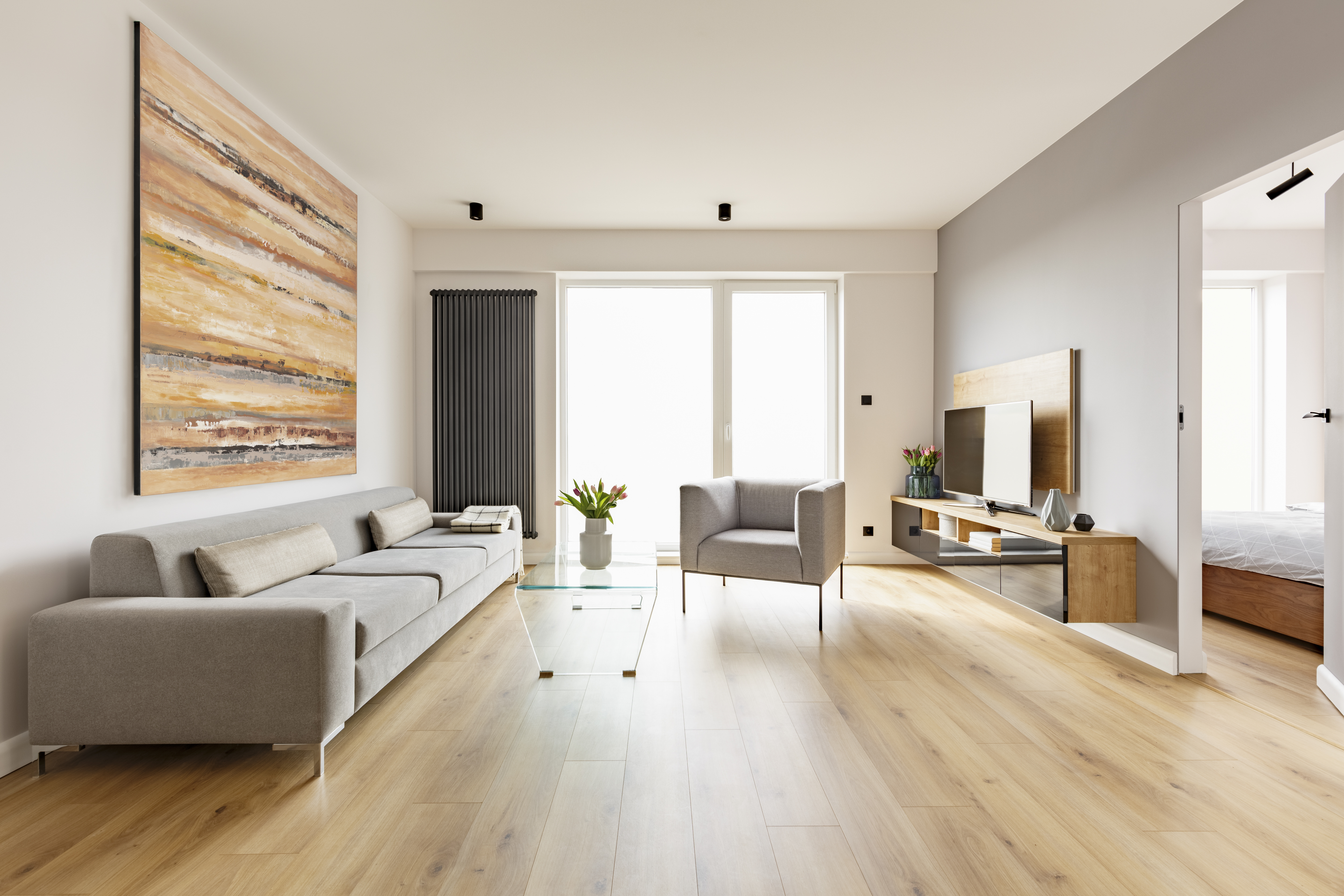 Sala minimalista con piso SPC madera clara · MCUADRA² Costa Rica